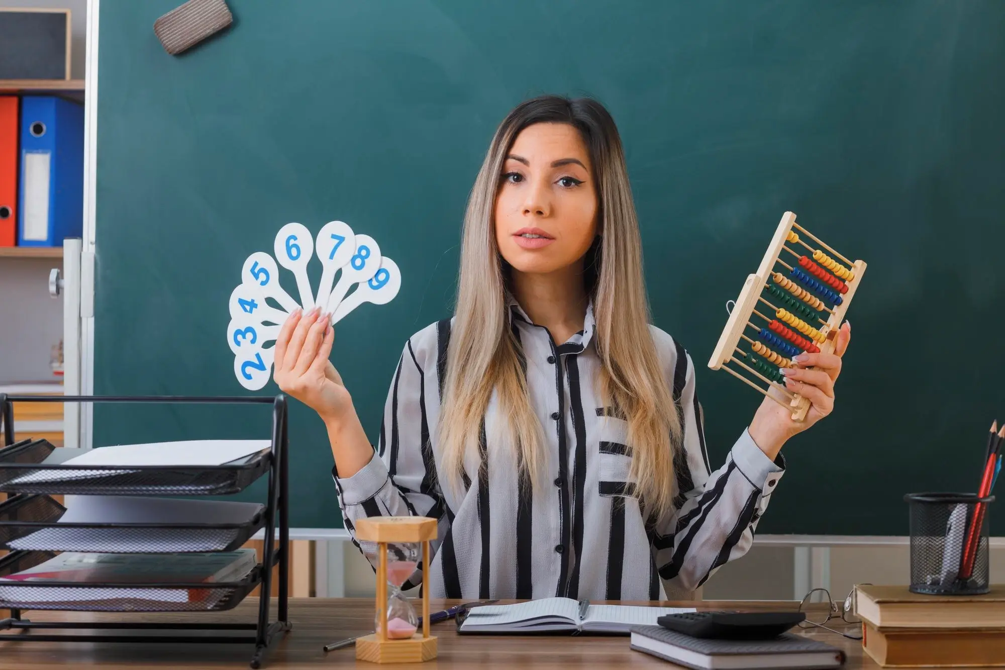 Professora mostrando Ábaco e Material Dourado